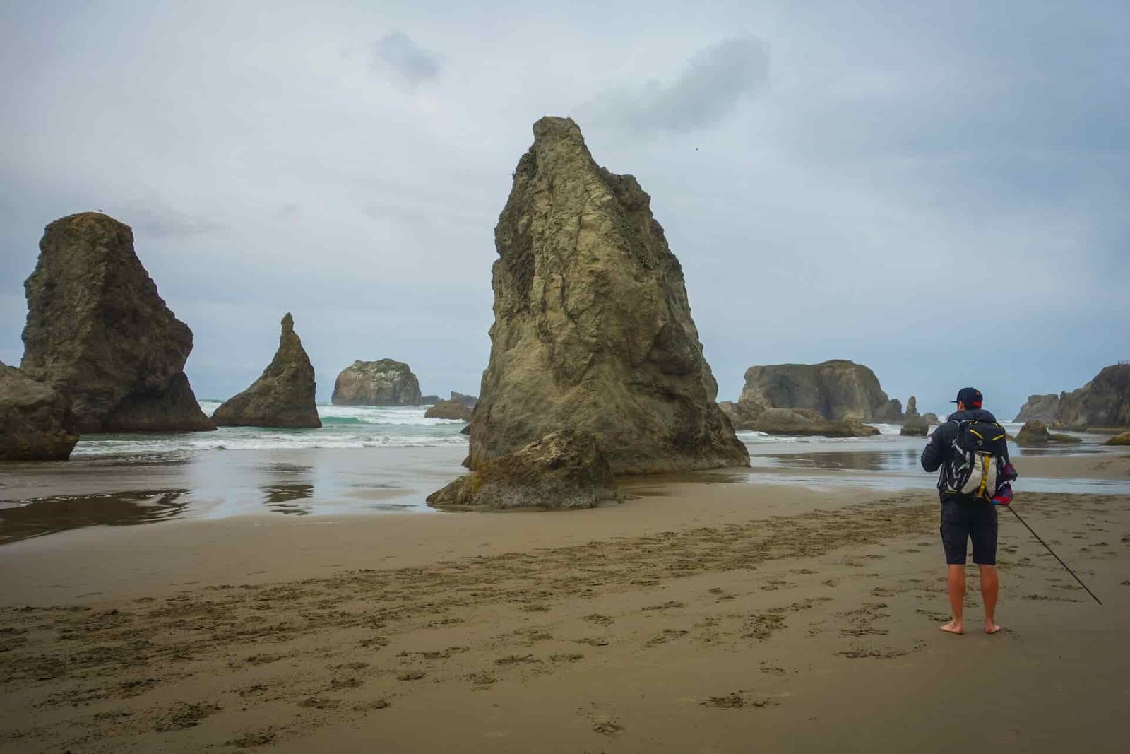 backpacker on the oregon coast trail looking out at the massive sea stacks.