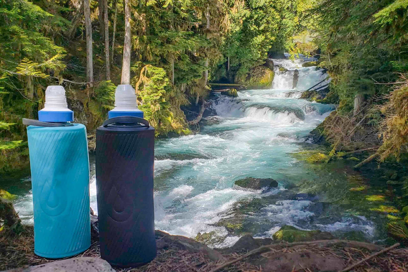 Hydrapak Flux water bottles with Katadyn BeFree water filters in front of a clear-blue river