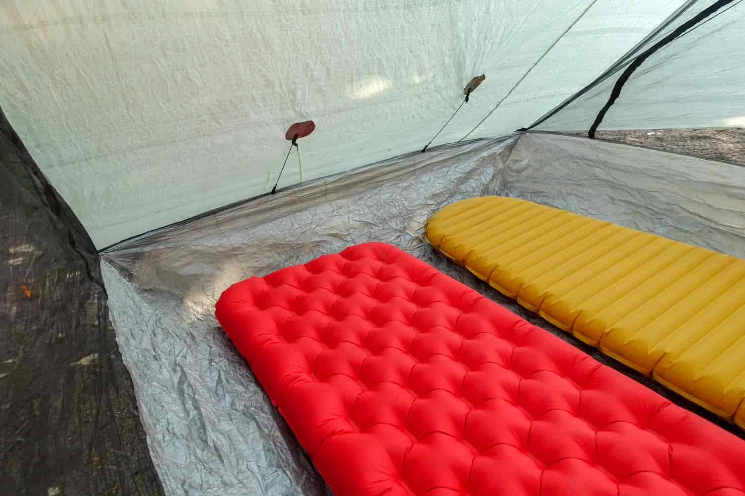 the inside of a zpacks triplex withe two sleeping pads set up and plenty of floor space around them