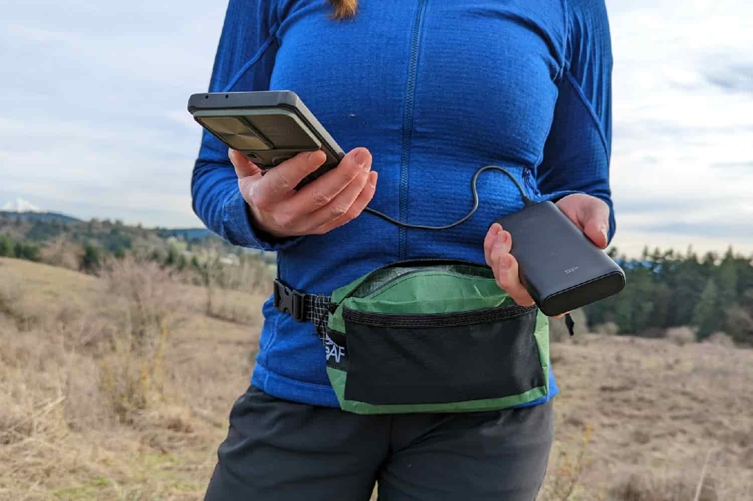 person charging their phone with a portable battery bank