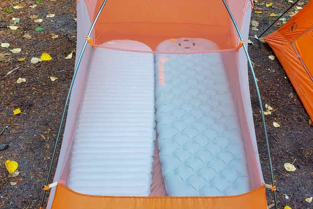 2 regular-size sleeping pads inside an orange 2-person tent leave virtually no open floor space 
