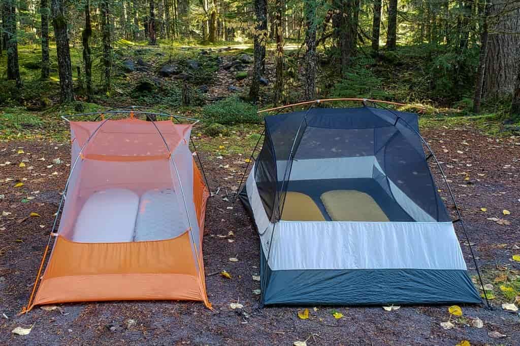 The 2-person tent on the left barely fits two sleeping pads while the tent on the right has more room with two of the same size sleeping pads