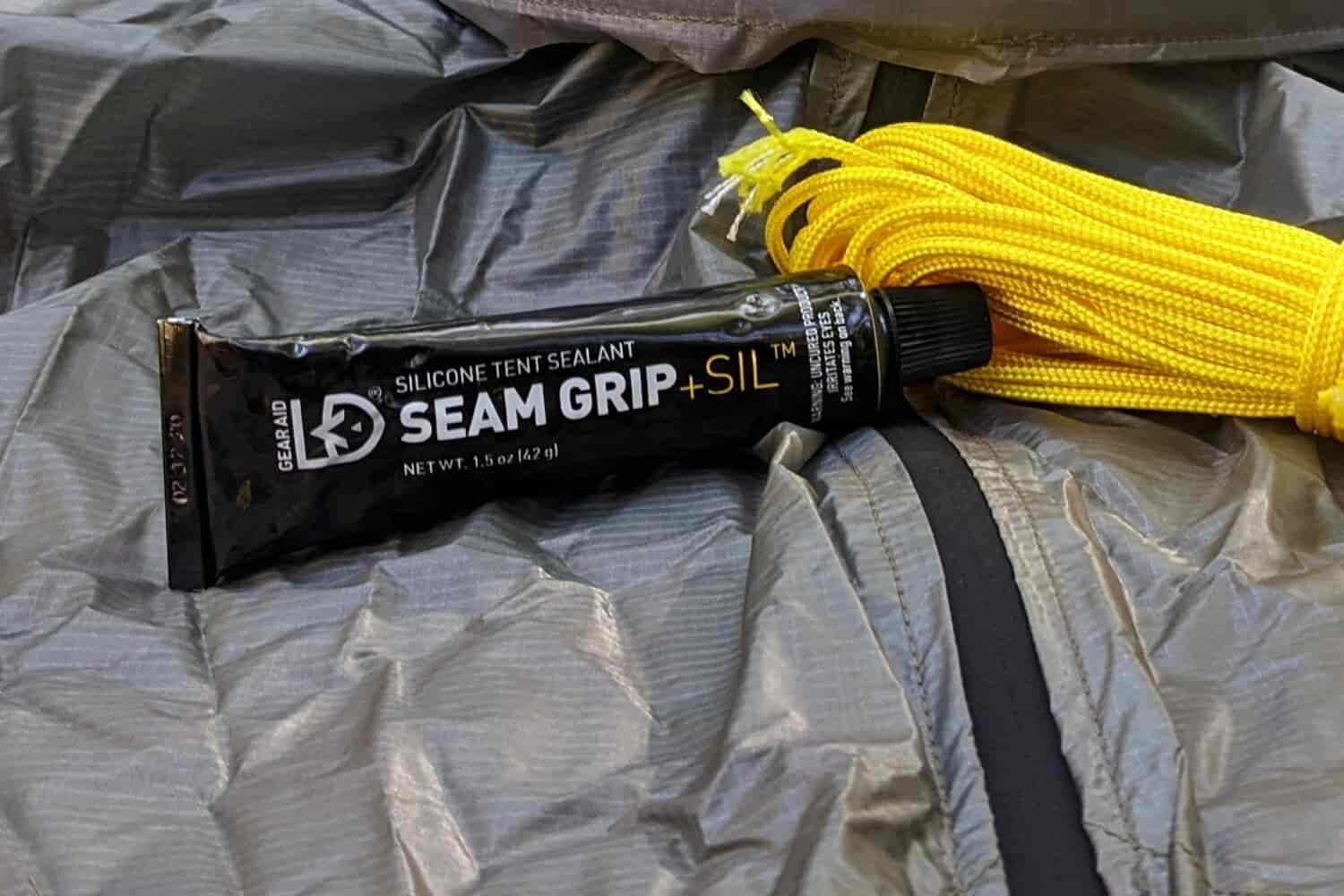 A closeup view of Seam Grip tent sealant and guylines resting on top of the six moon designs lunar solo ultralight backpacking tent