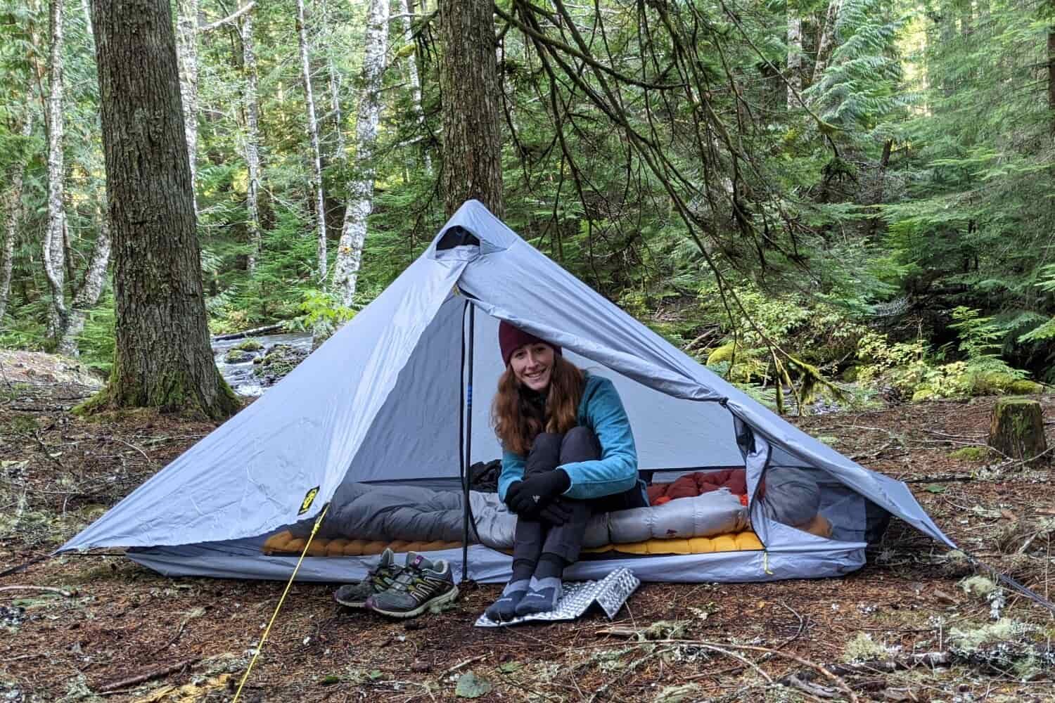 A hiker sitting in the door of the Six Moon Designs Lunar Solo tent