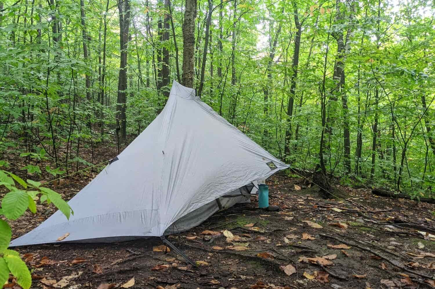 A side view of the Six Moon Designs Lunar Solo tent set up in a forest
