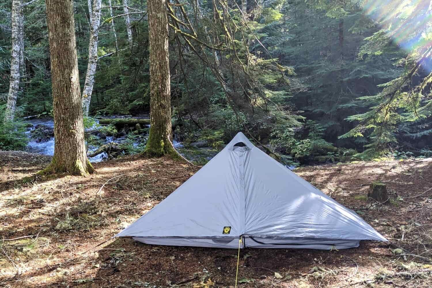 the six moon designs lunar solo tent set up beside a river