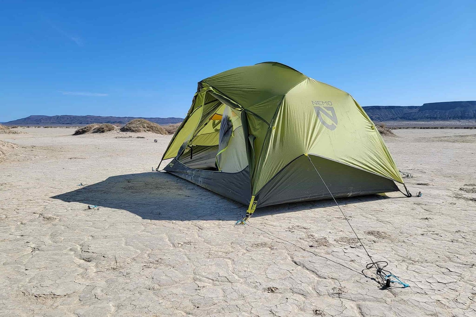 a sunny cloudless day on the playa with a nemo dagger tent set up with the guylines pulled and staked out.