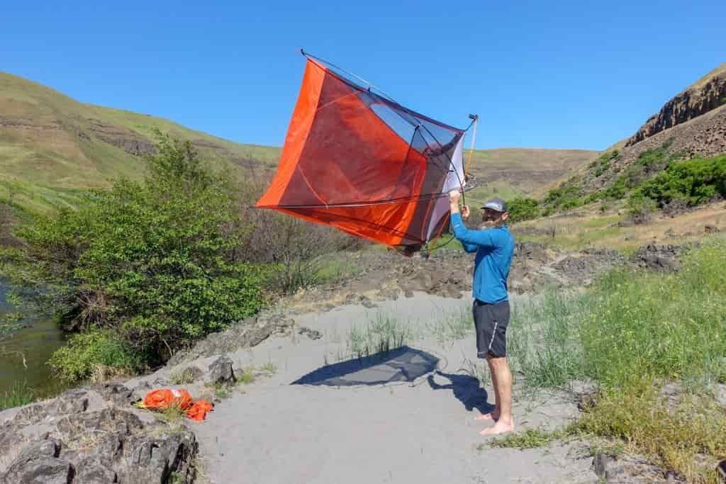backpacker shaking out their tent