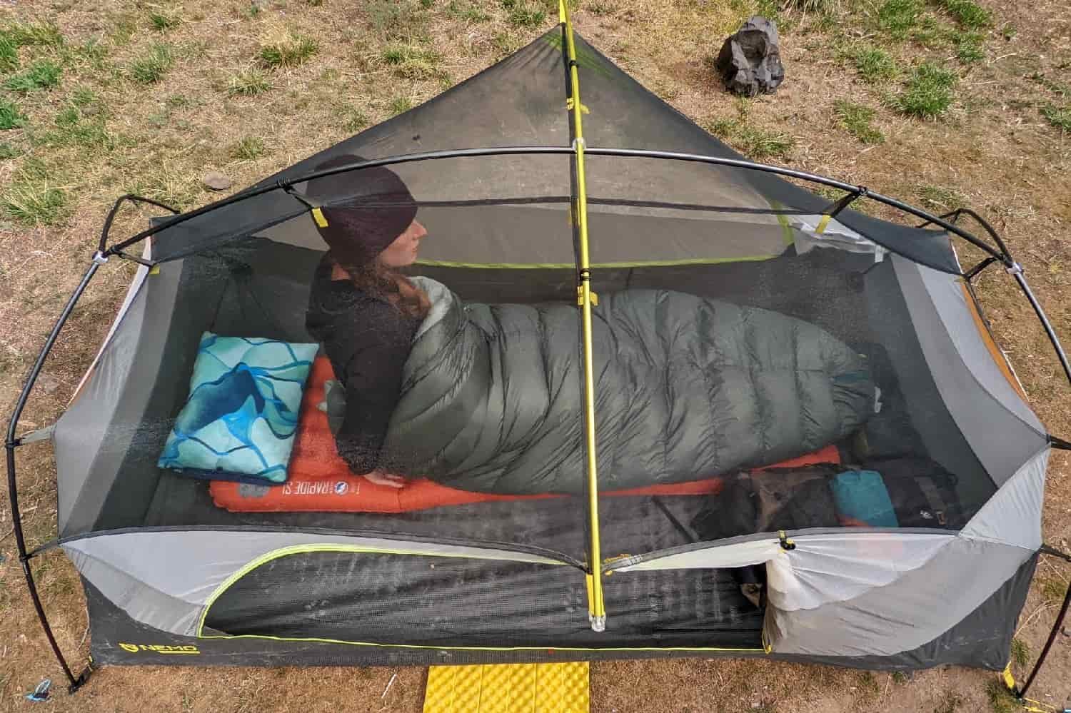 a top down view of a backpacker inside the nemo dagger still in her sleeping bag