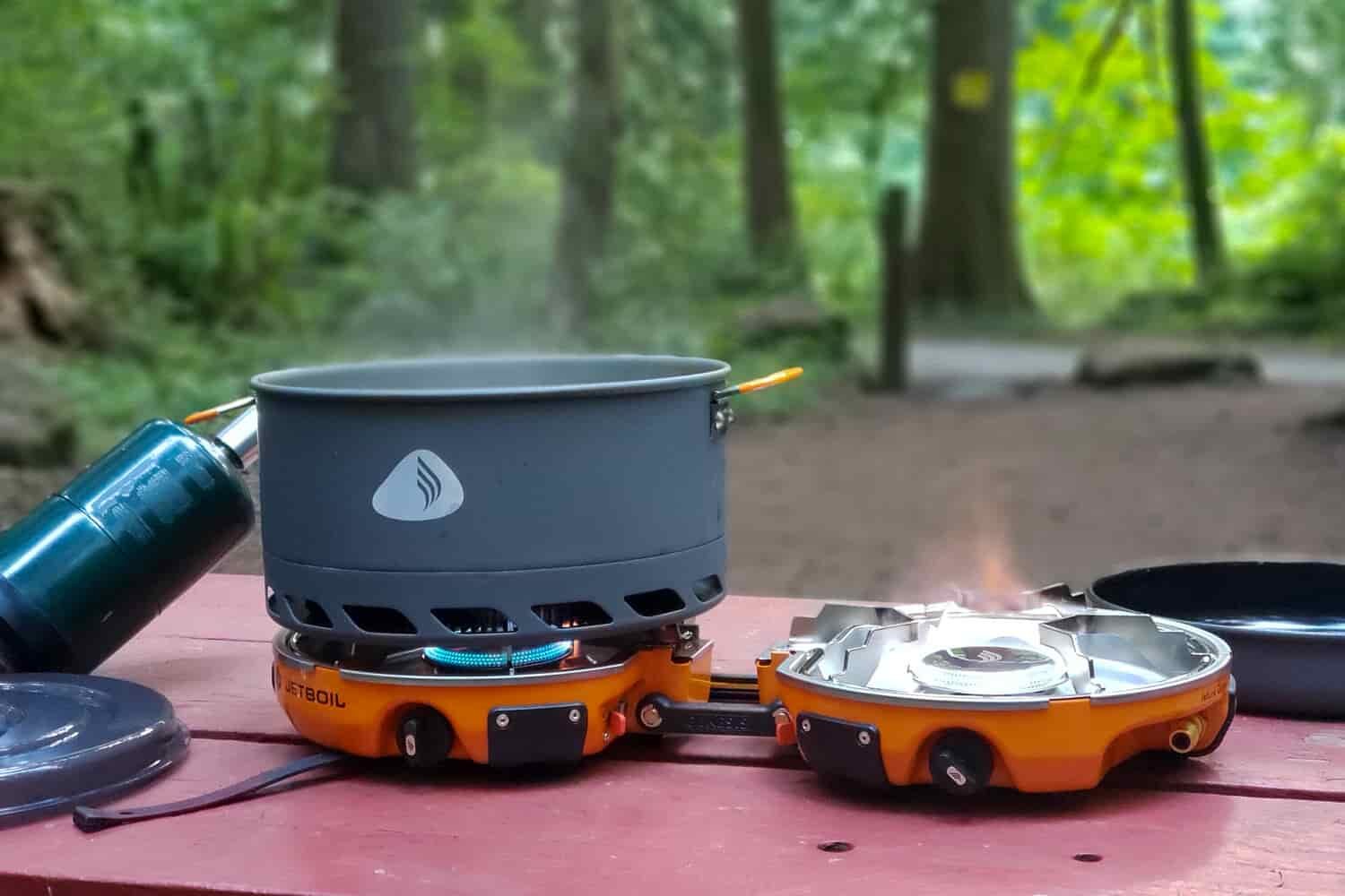 The Jetboil Genesis Basecamp System being used to boil water in a campsite on a picnic table