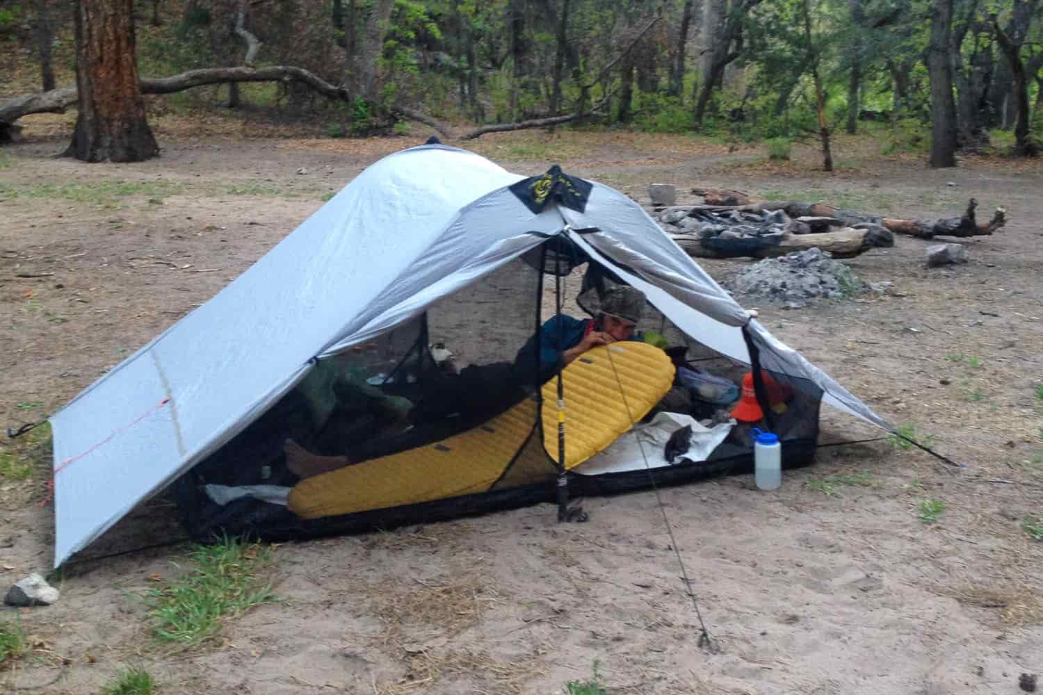 CDT thru-hiker inside a tent blowing up his sleeping pad
