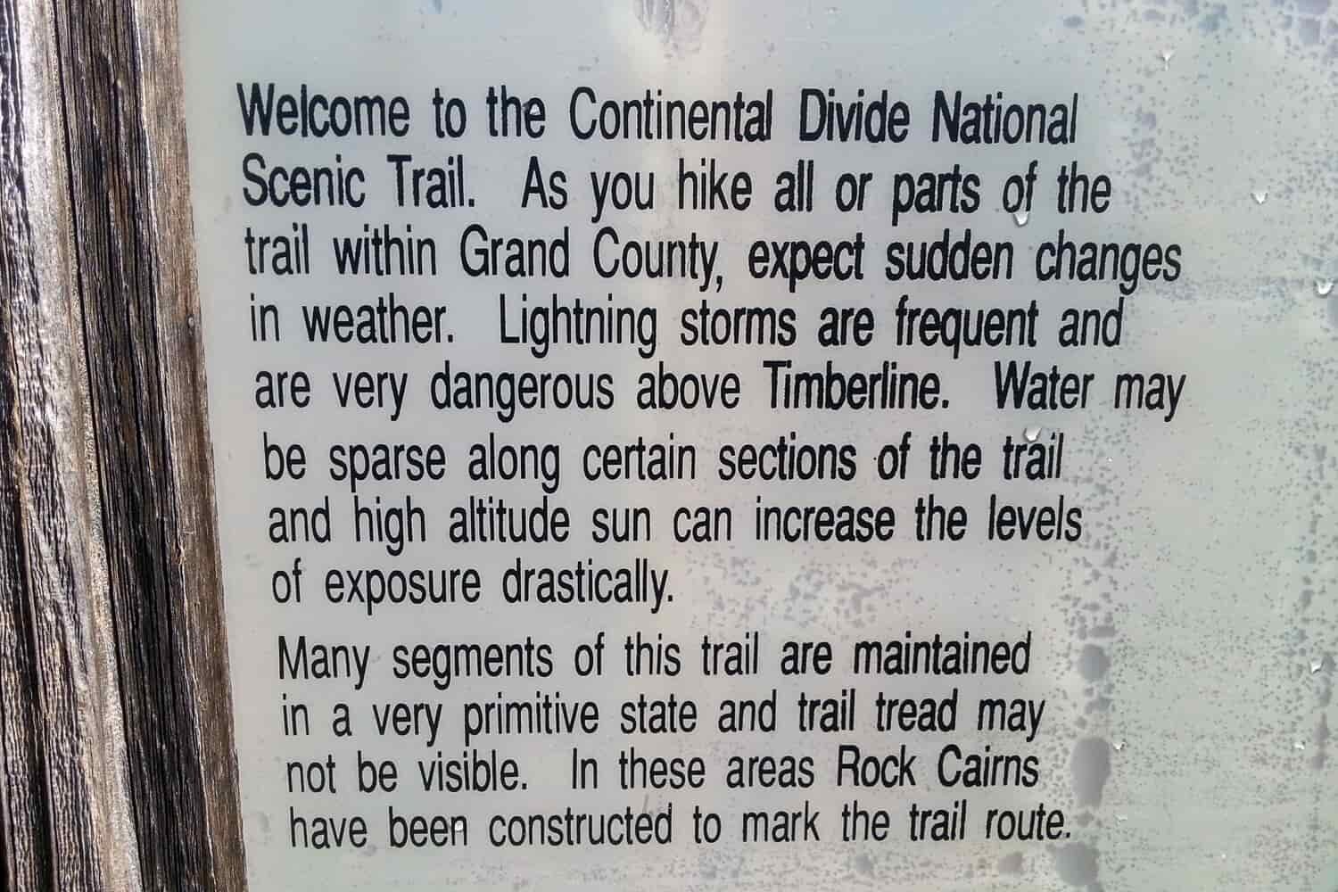 Picture of a sign that says:
Welcome to the Continental Divide National
Scenic Trail. As you hike all or parts of the
trail within Grand County, expect sudden changes
in weather. Lightning storms are frequent and
are very dangerous above Timberline. Water may
be sparse along certain sections of the trail
and high altitude sun can increase the levels
of exposure drastically.
Many segments of this trail are maintained
in a very primitive state and trail tread may
not be visible. In these areas Rock Cairns
have been constructed to mark the trail route.