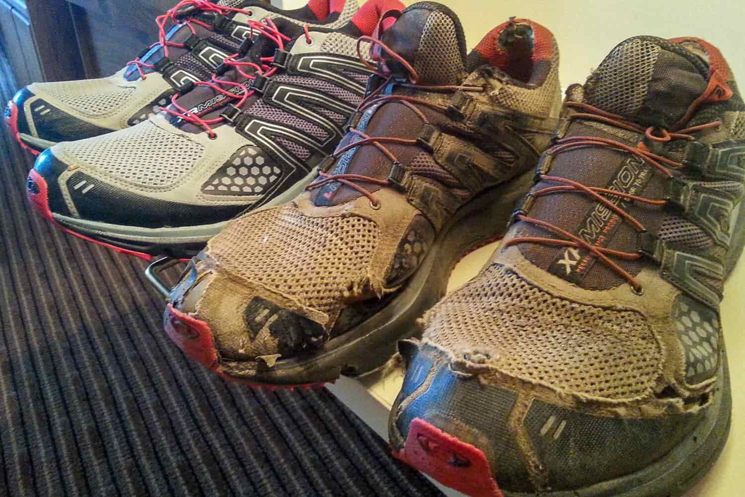 a brand new pair or trail running shoes lined up next to very worn out pair from miles on the CDT