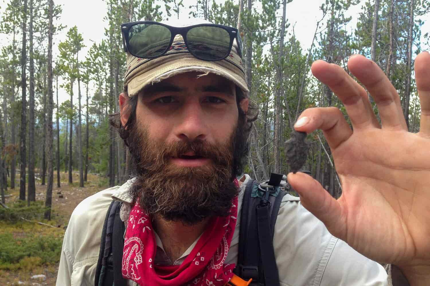 CDT thru-hiker holding up a found arrowhead