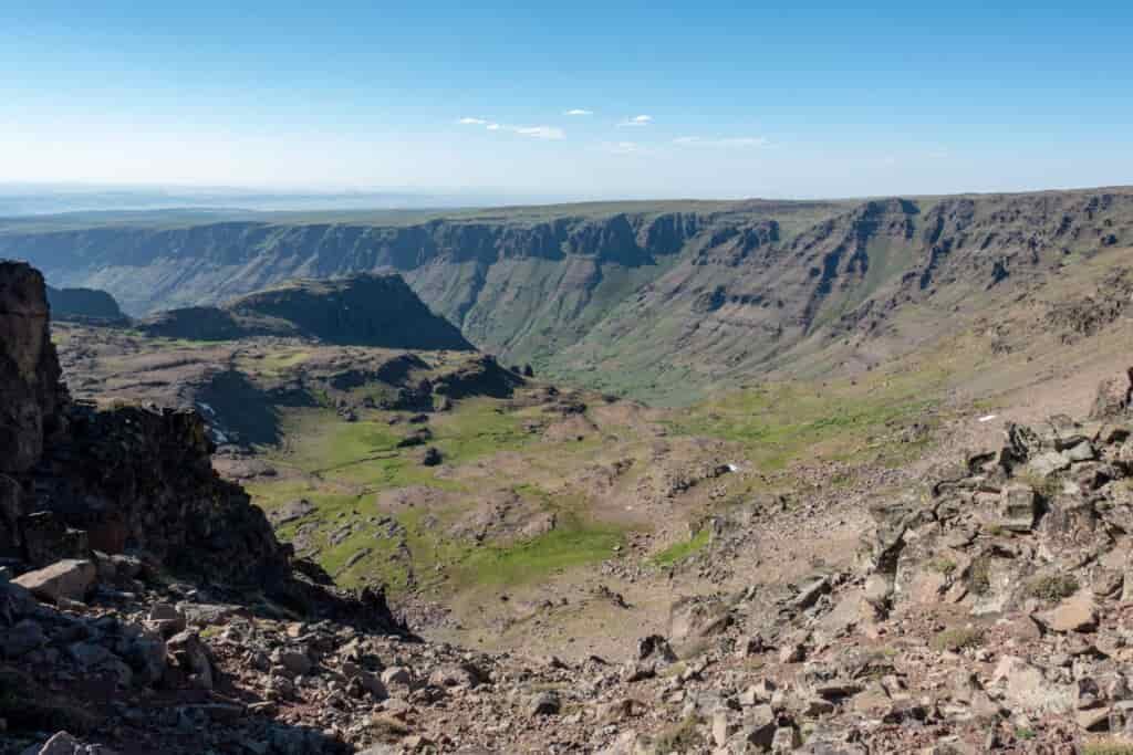 a view of the steens from the top showing steep red and green canyon walls