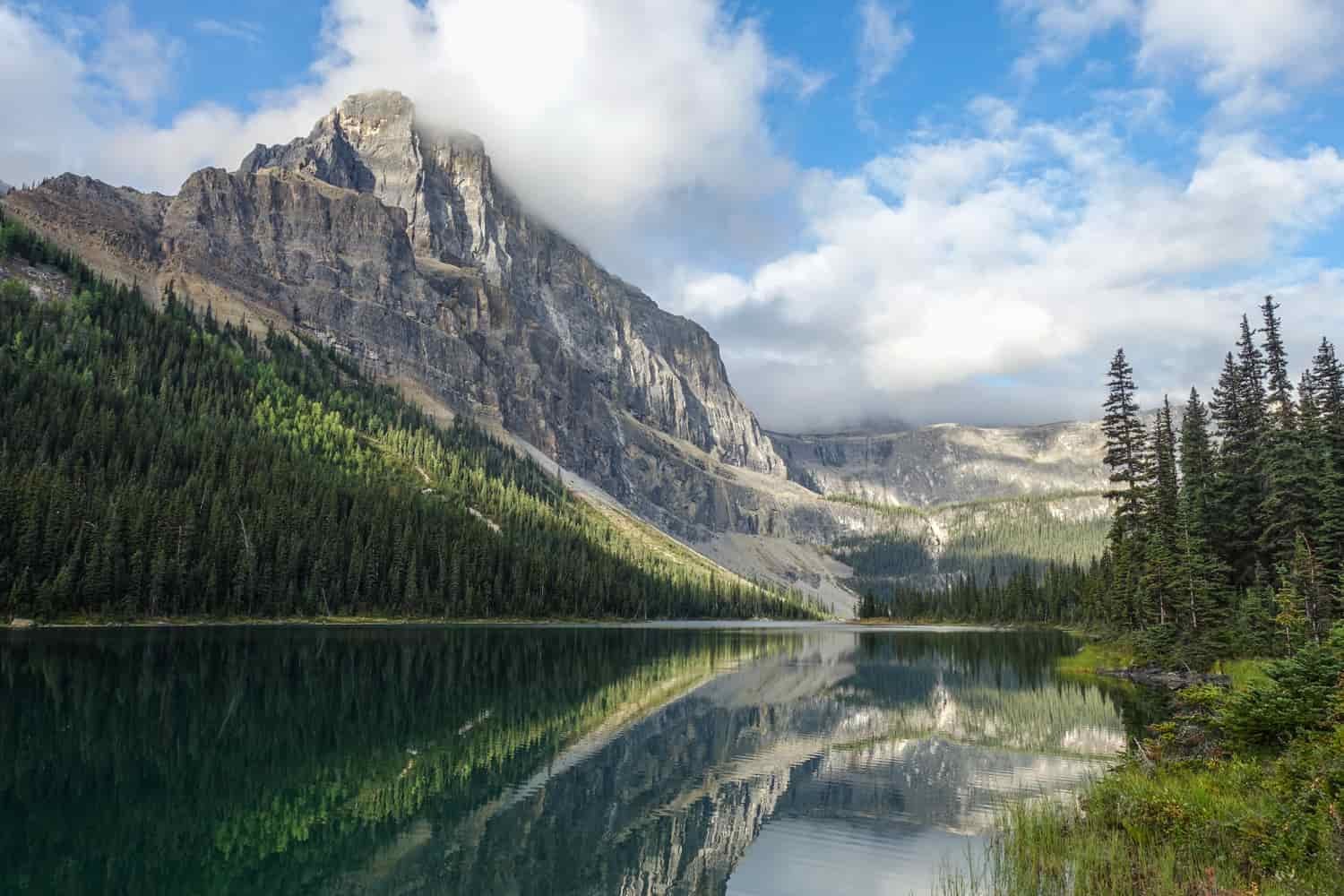 mountain reflected on a lake on a partly sunny day in banff national park