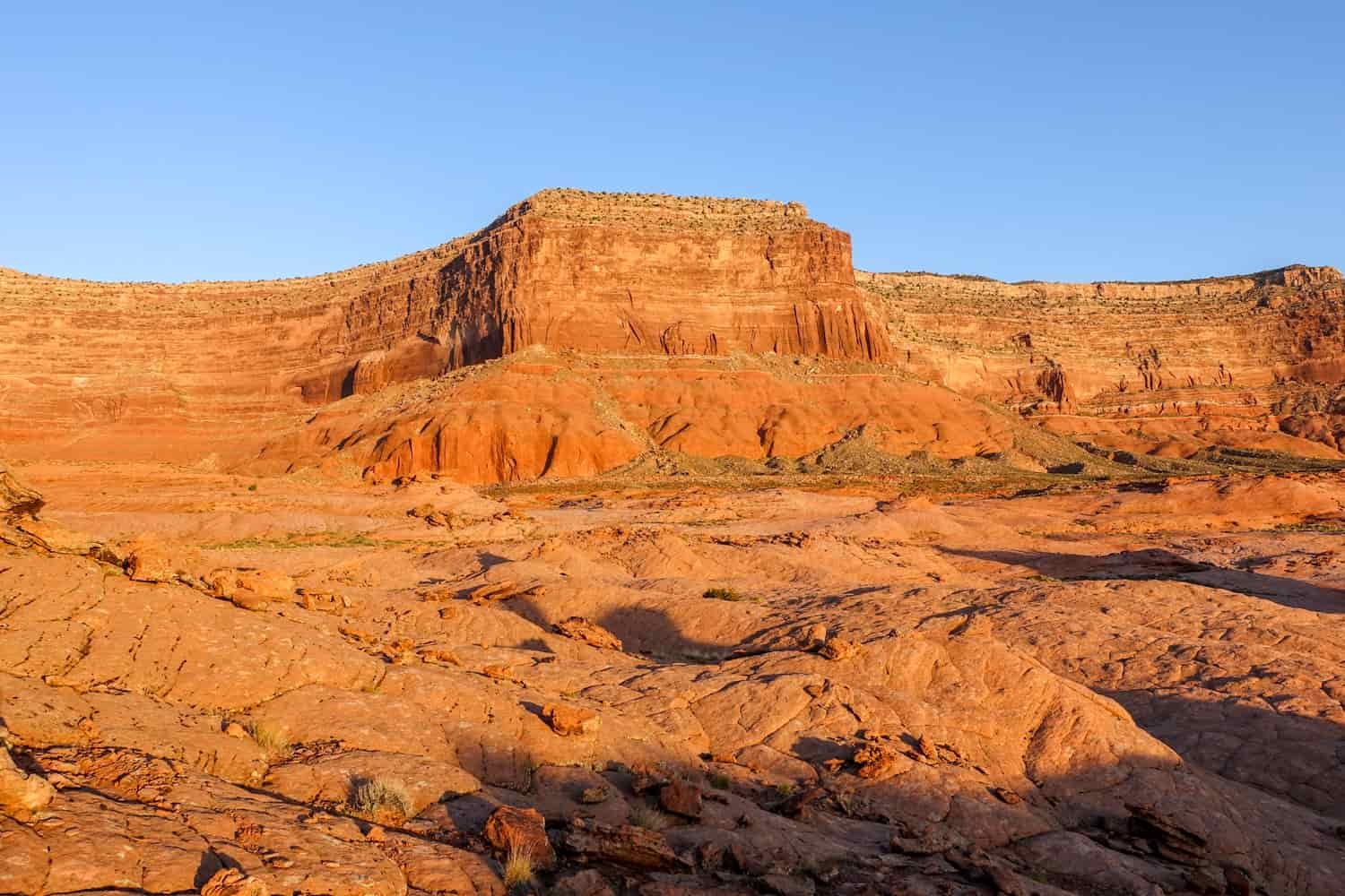 a squared off butte with dramatic shadows and a bright blue sky