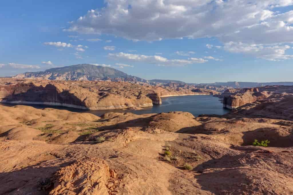 a large view of a canyon filled with water and blue skies with clouds