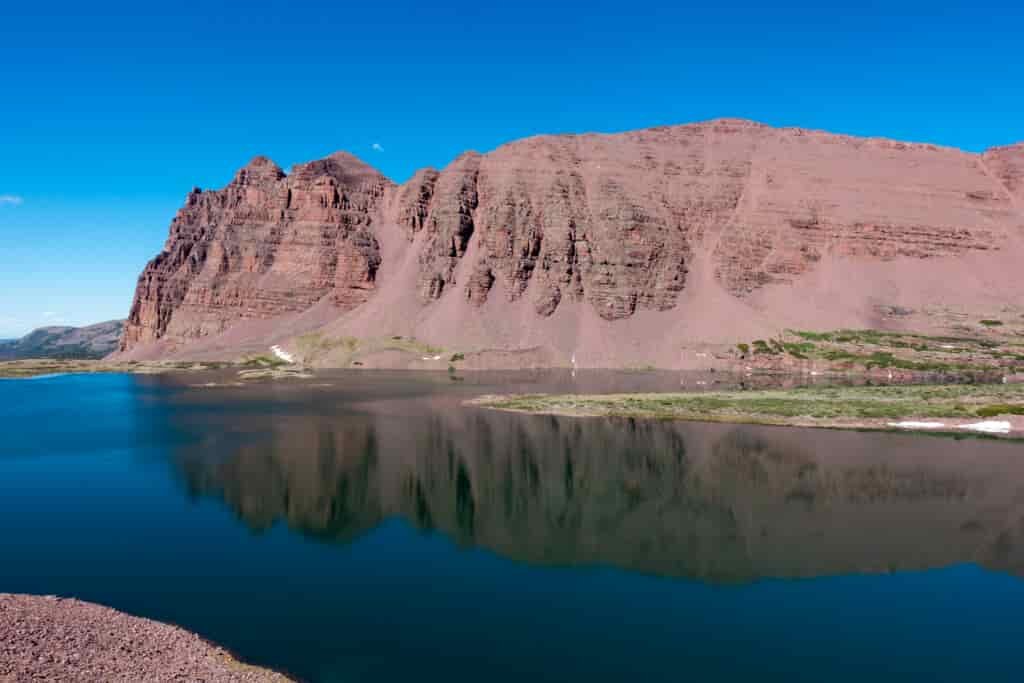Another blue mountain lake reflecting the reddish-brown mountain behind it