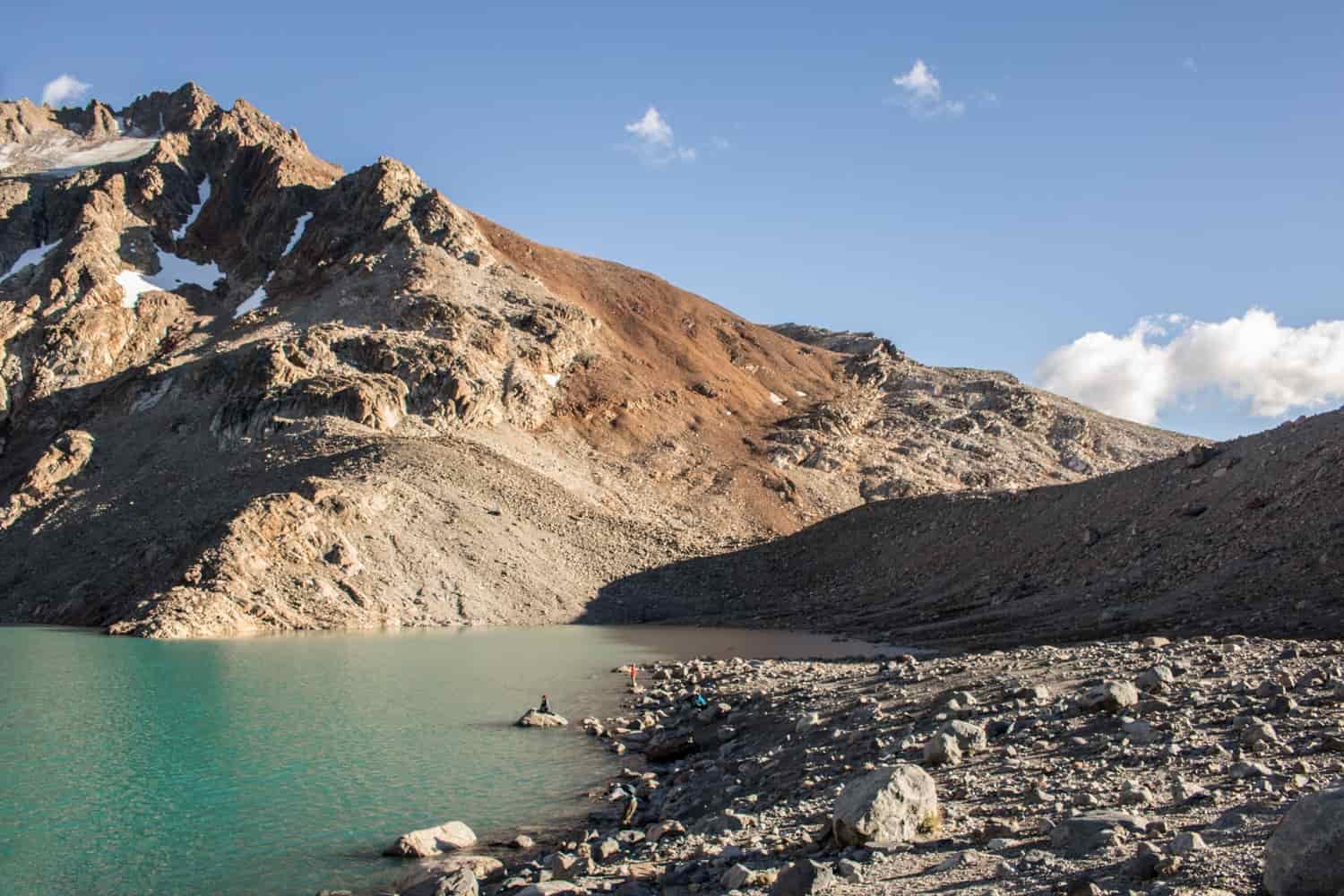 A lake provides contrast against rugged mountains