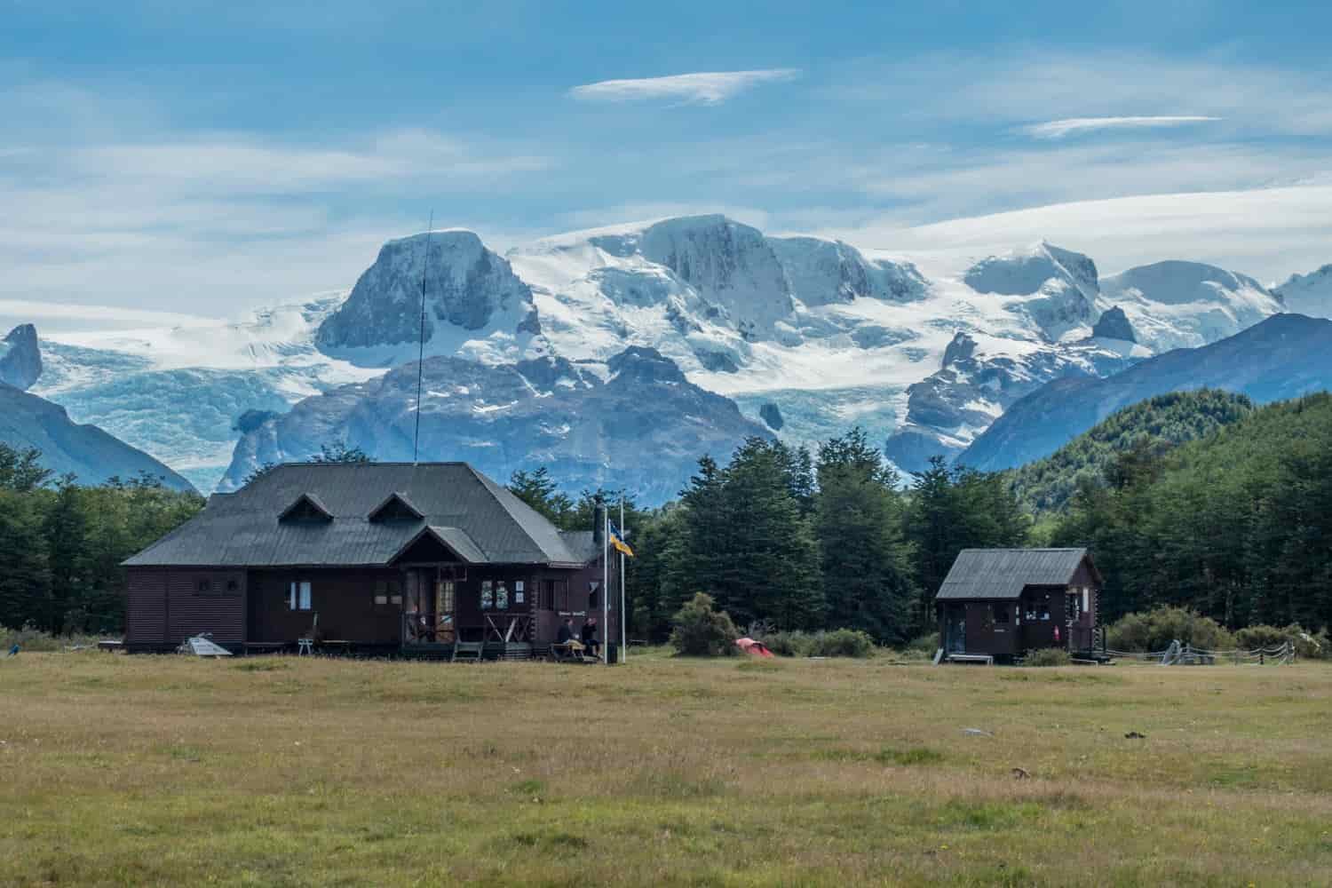A mountain lodge with snowcapped mountains in the background
