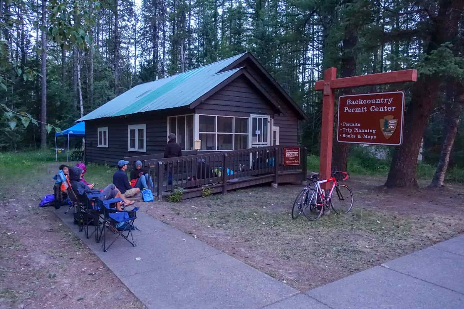 backcountry permit station in glacier national park with a seated line of backpackers waiting for the office to open