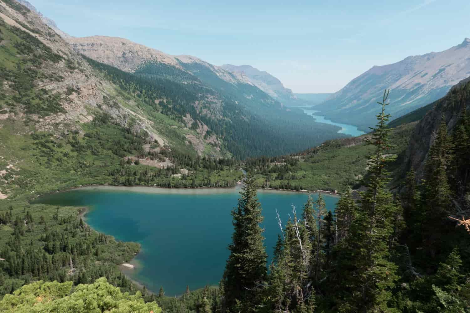 glacial lake in glacier national park with a narrow valley lake behind it