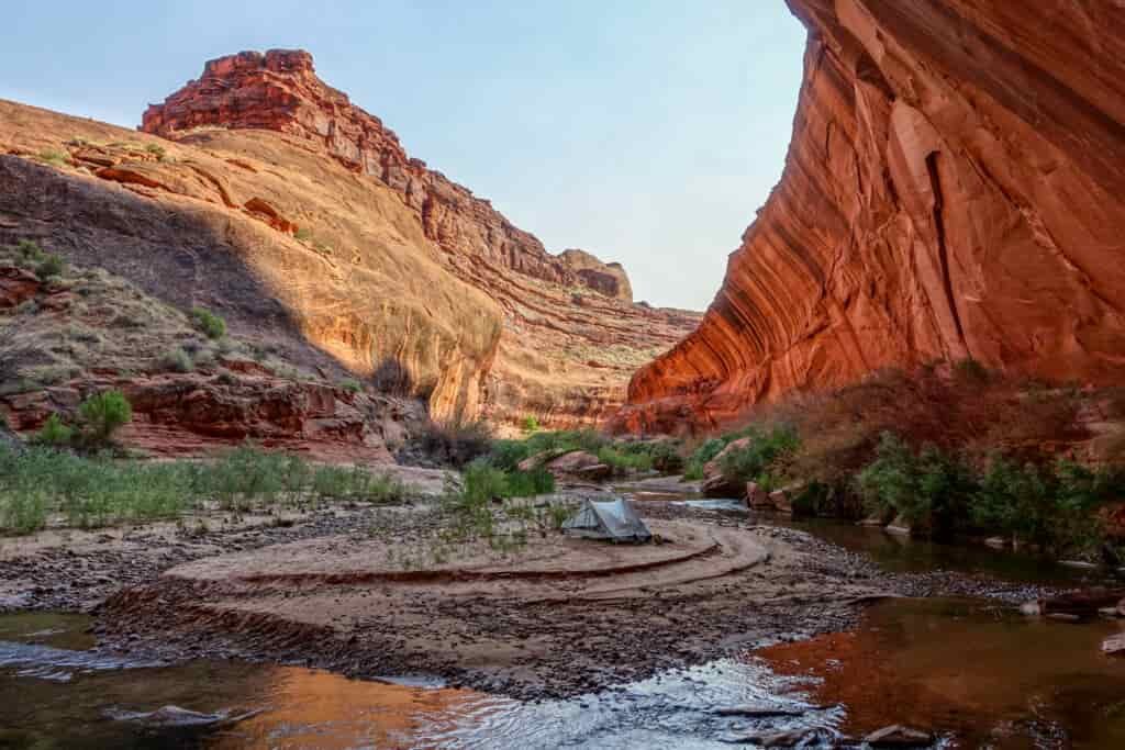 large orange rocks with a calm river running below