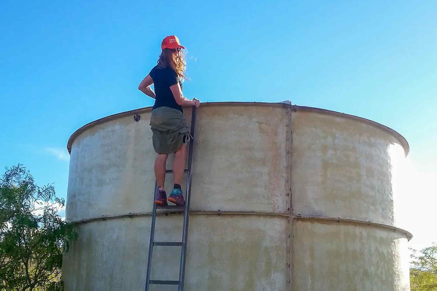 a water tank with a hiker on its ladder