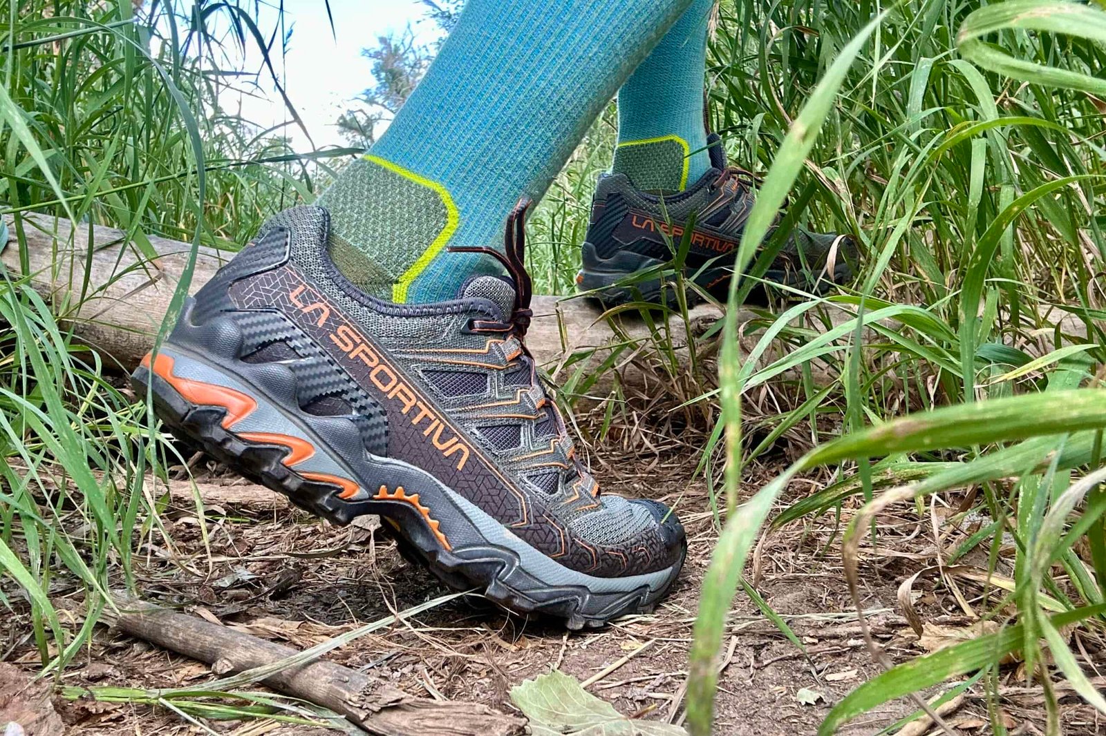 Close up of a hiker walking in a forested setting from the knees down.