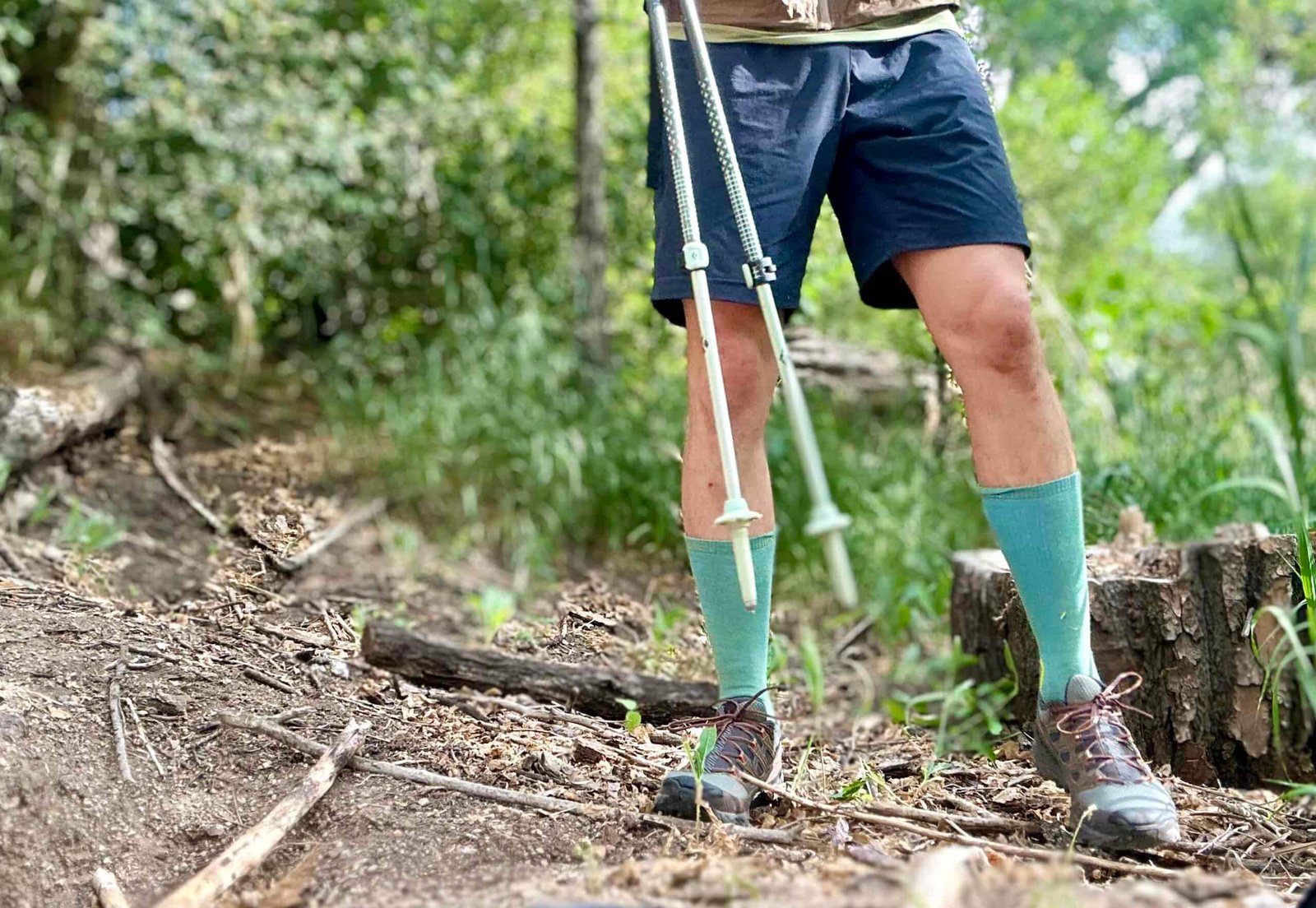 A hiker from the waist down poses in a forest setting
