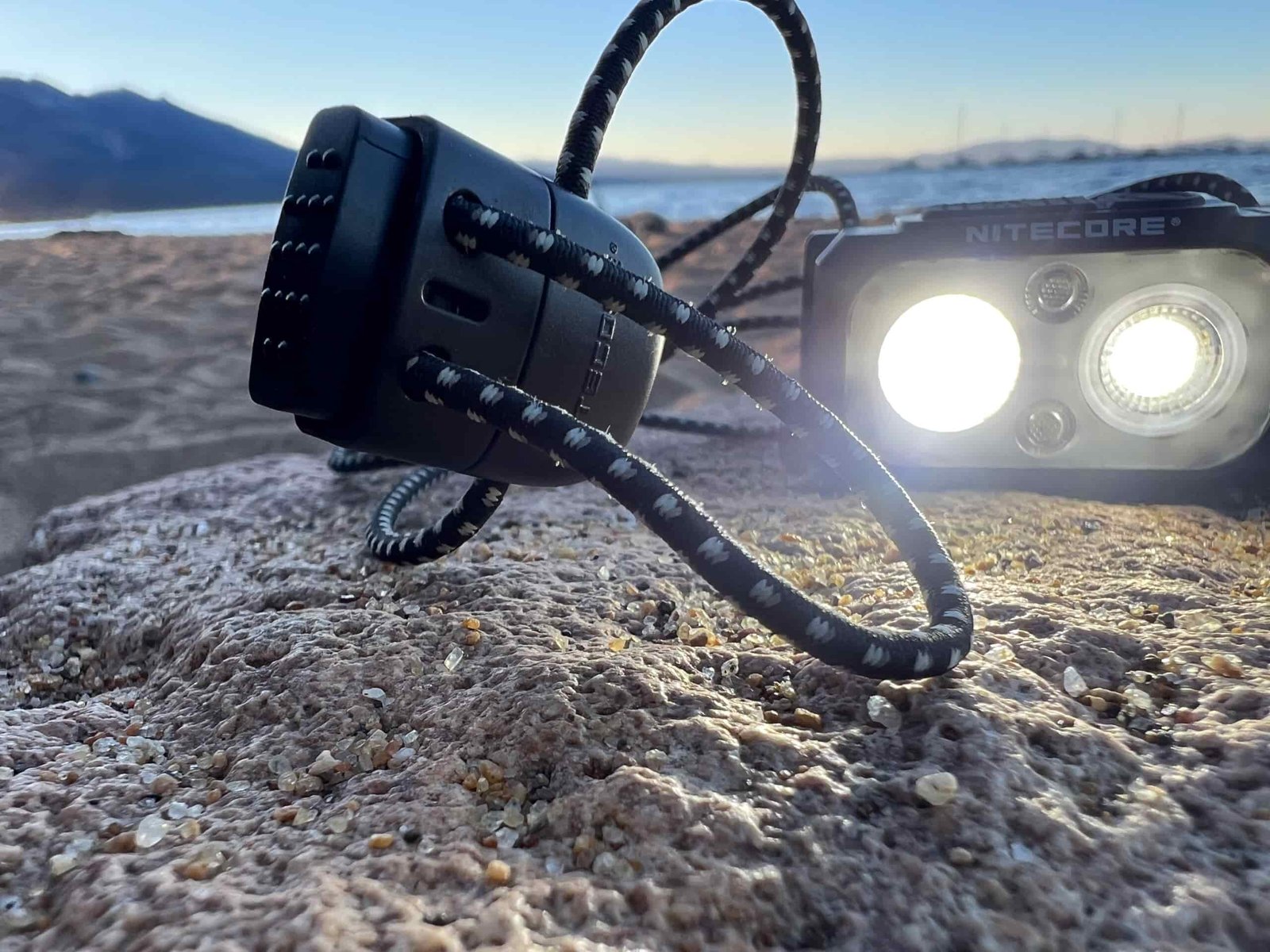 The image shows a headlamp illuminating it's strap in the foreground.