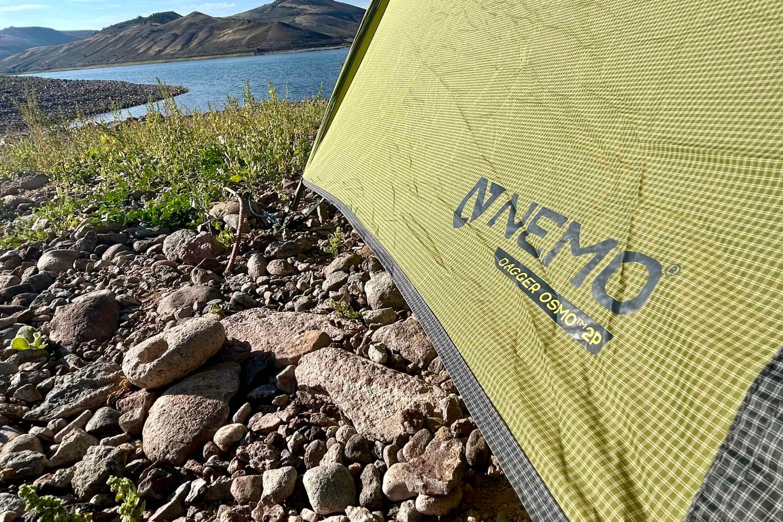 Tent fly of the NEMO Dagger OSMO 2 with a lake and mountains in the background.