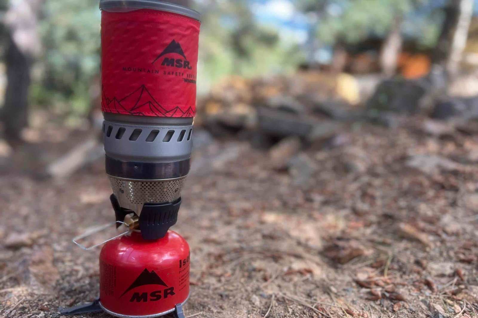 A side shot of the WindBurner completely installed with pot, stove, fuel, and canister stand. The background is blurry.