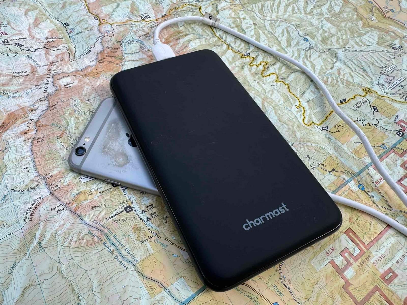 The Charmast power bank and a phone sit on a map.