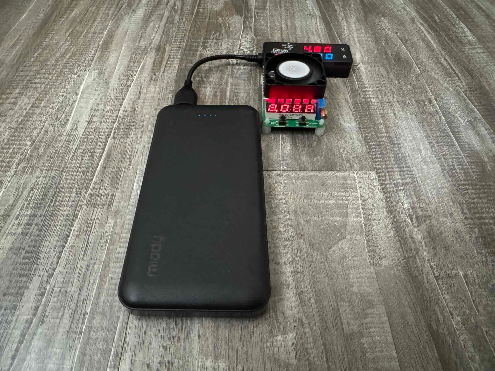 Close up of the Miady power bank plugged into a multimeter and dummy resistor load.