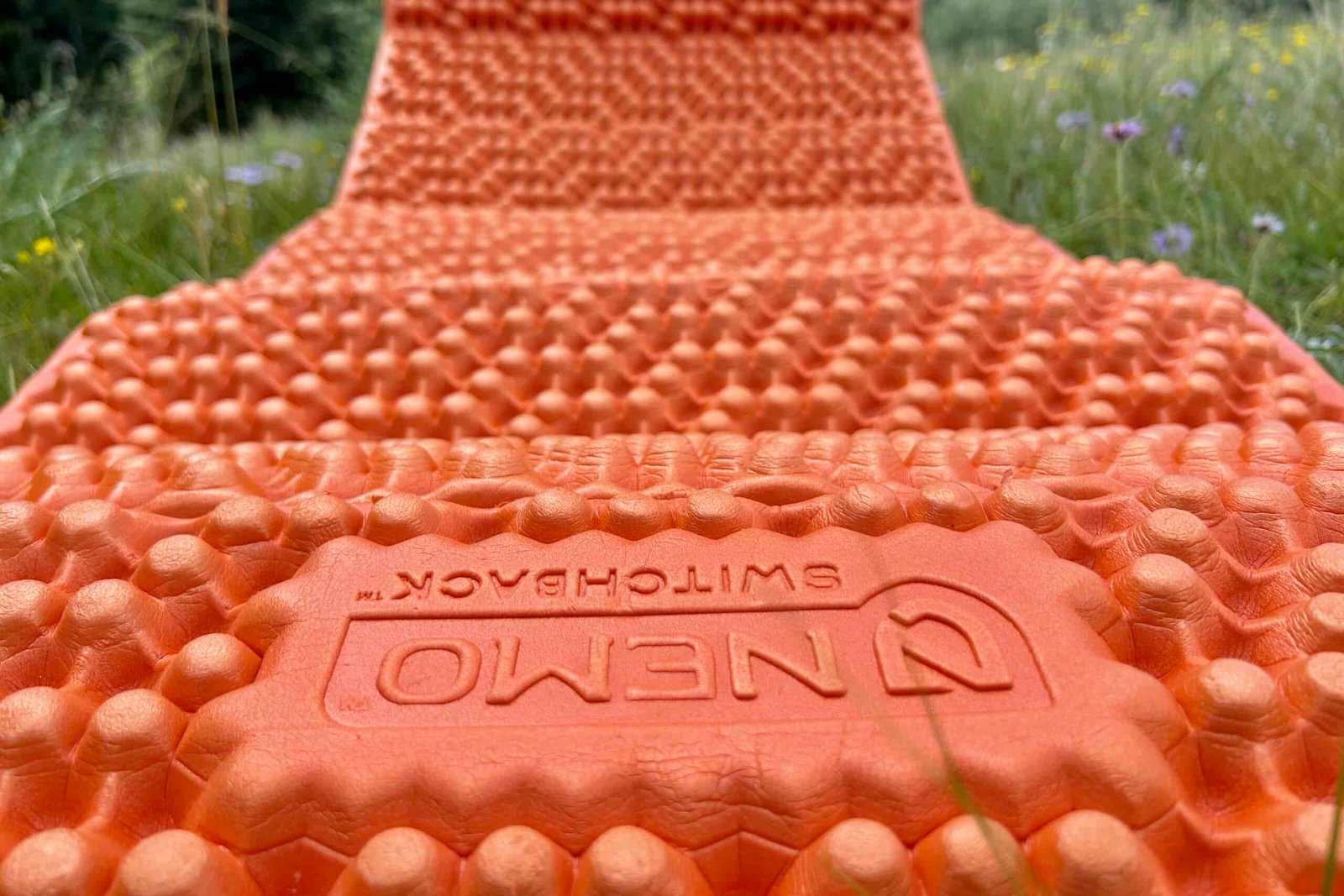 Close up of a bright orange foam mat showing its bumpy texture.