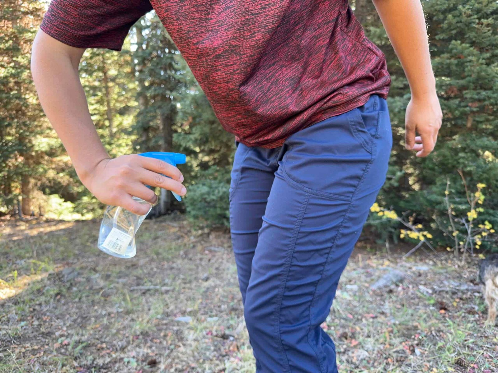 a gear analyst spraying her pants with water to test weather resistance