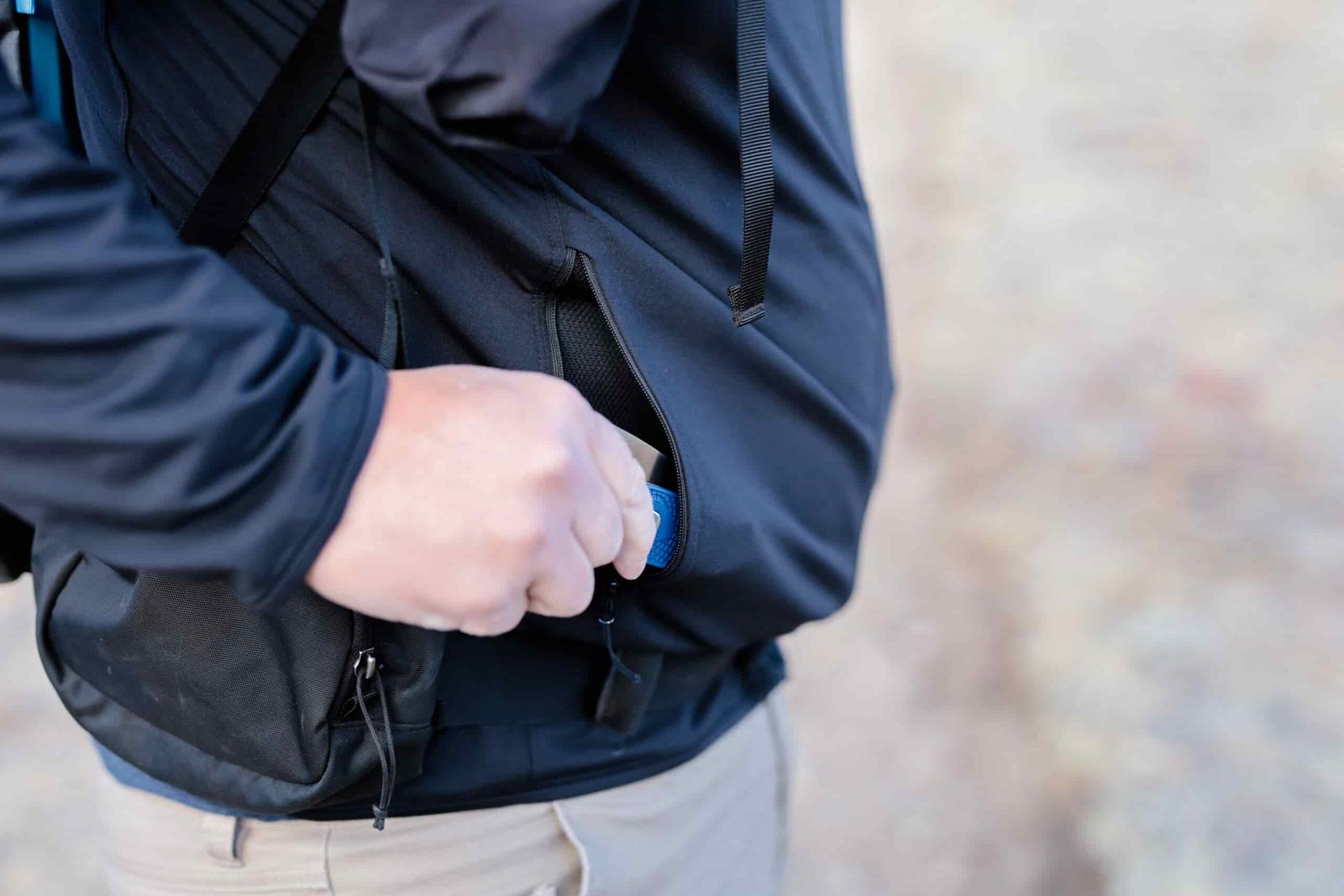 Hand pulls a pocket knife out of a hoodie pocket.