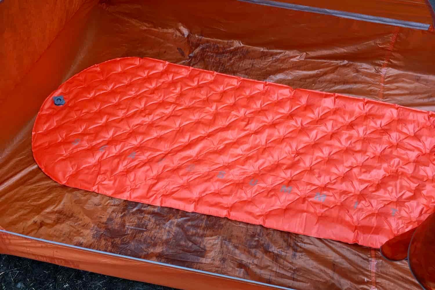 A deflated sea to summit ultralight insulated sleeping pad inside a backpacking tent