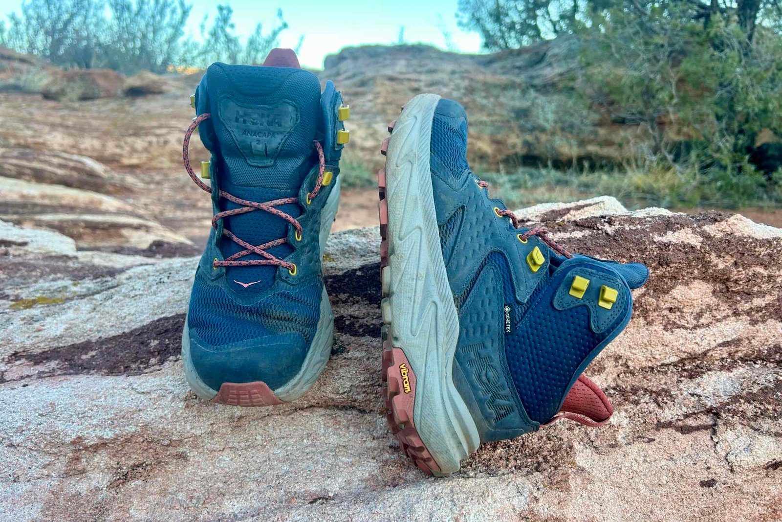 Close up of a pair of hiking boots posed on a rock.