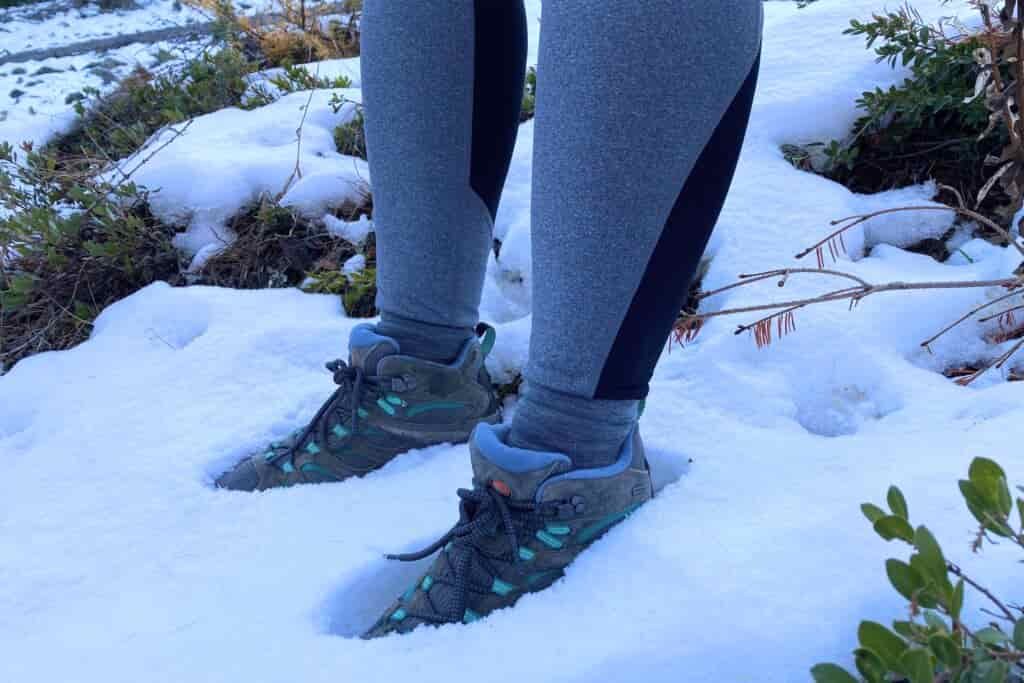 Hiker wearing the Women’s Merrell Moab 3 WP and standing in the snow