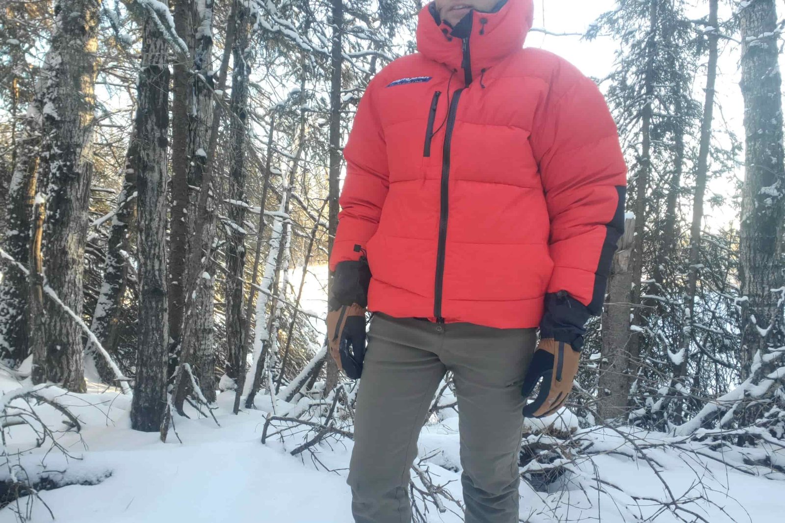 A closeup of a main standing in a wintery forest.