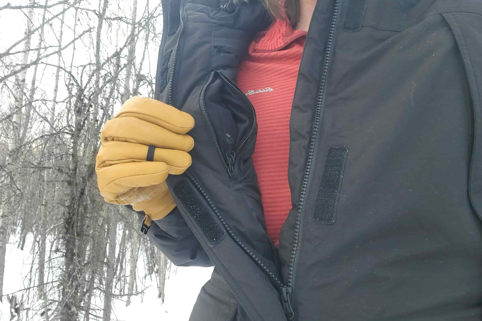 A man shows the interior pocket on a jacket.
