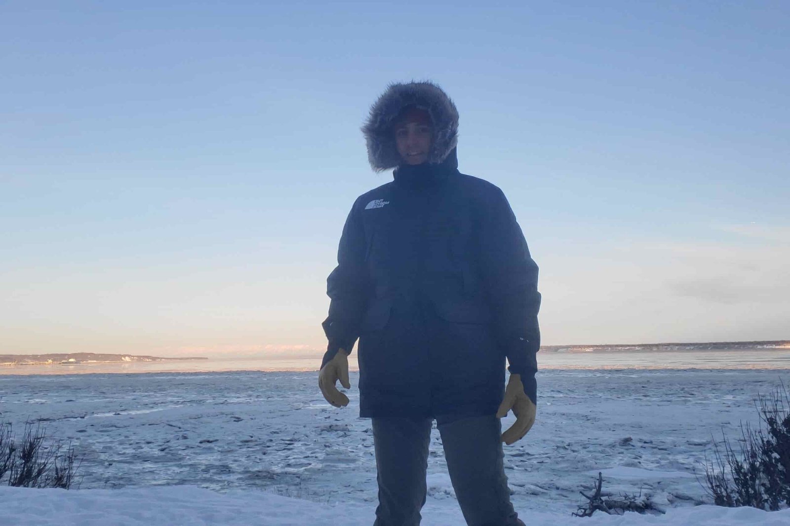 A man stands with a fur ruff coat.