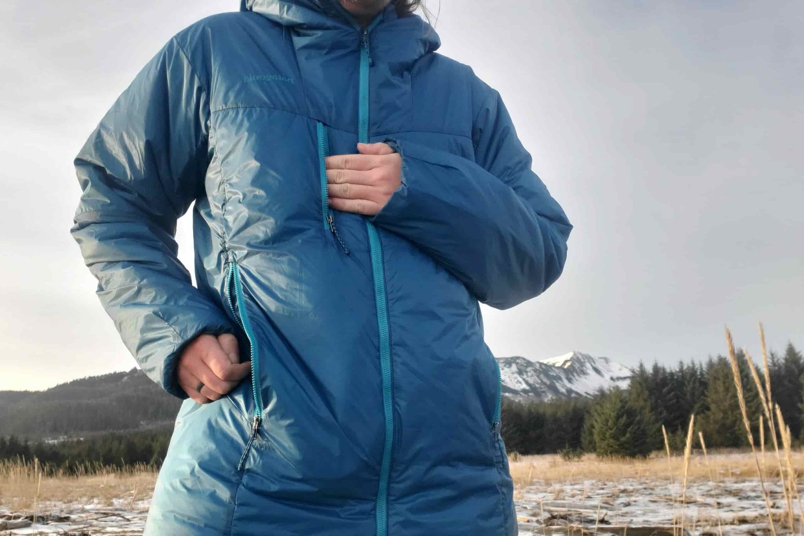A closeup of the front of a jacket as a man shows the pockets.