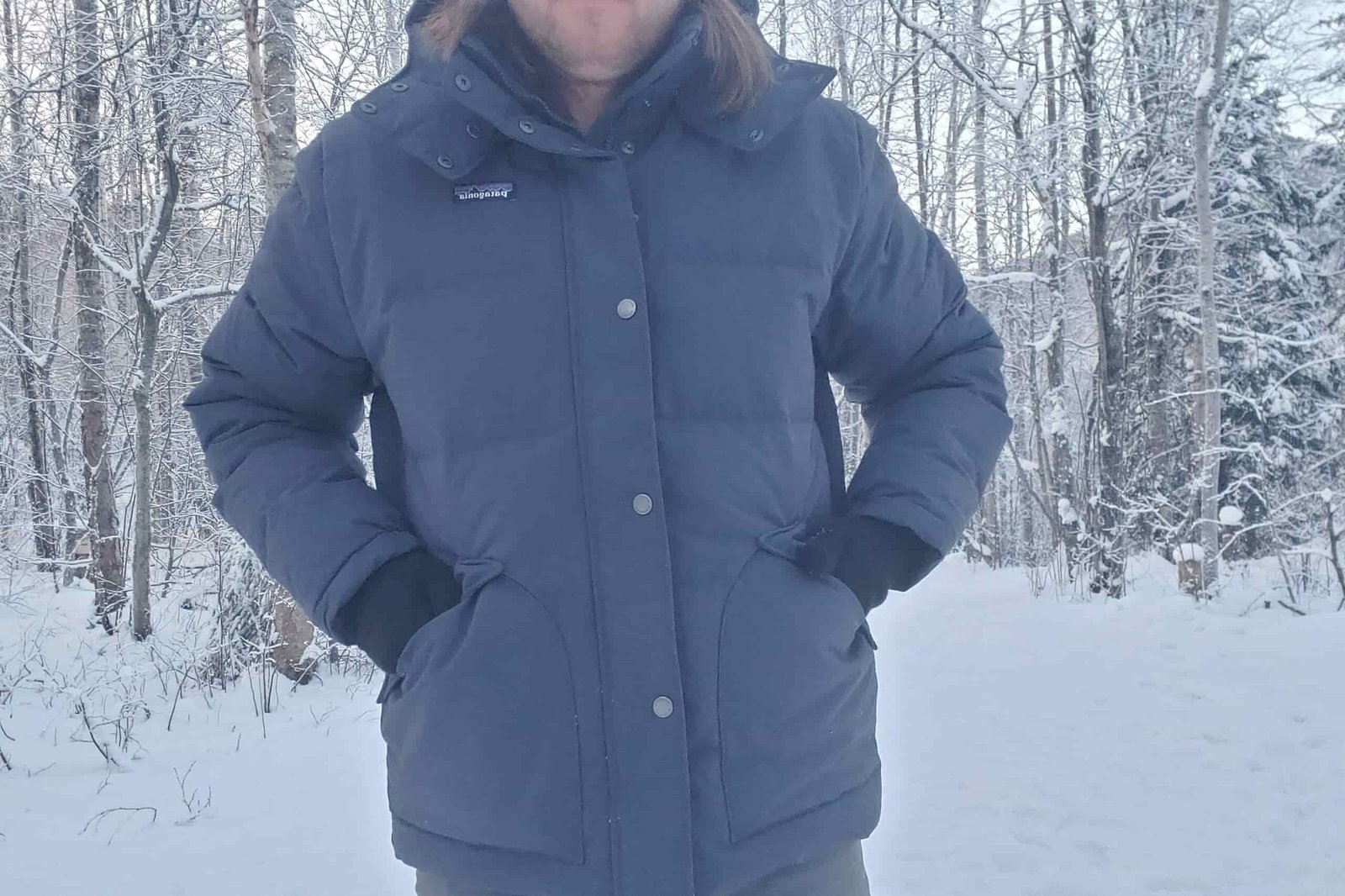 A closeup of a pan putting gloves in the pocket of his jacket.