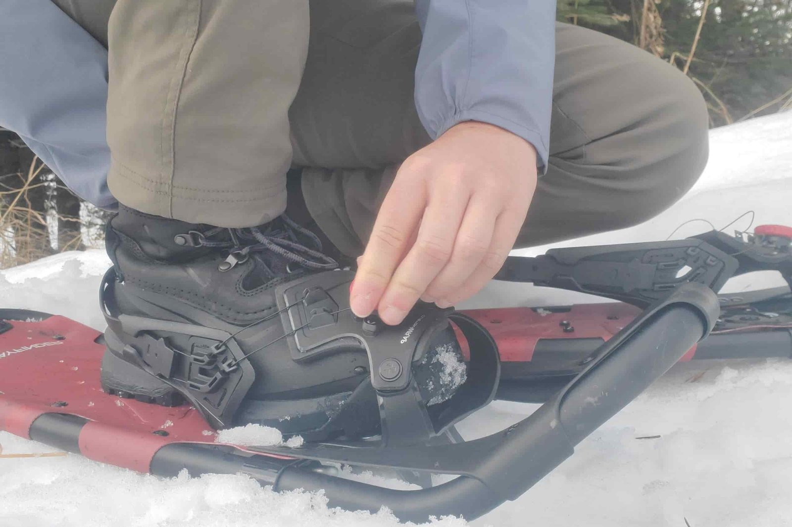 A man tightens a pair of snowshoes