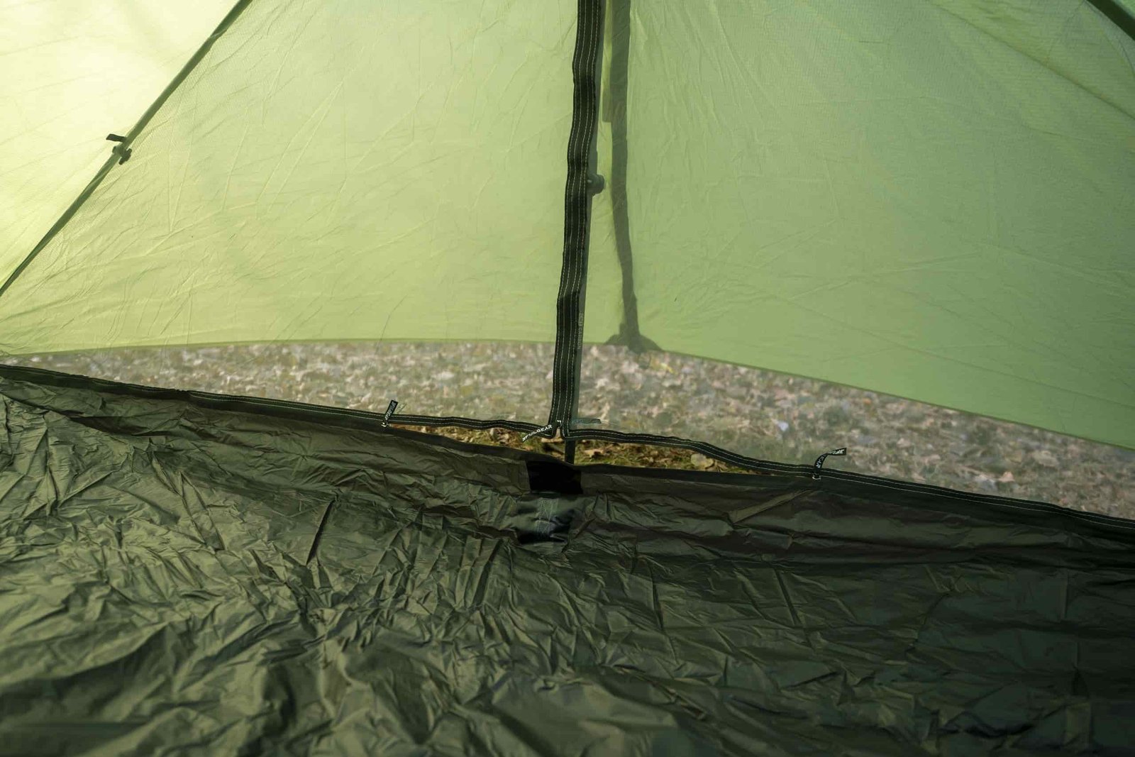 a view inside a green tent looking at two doors