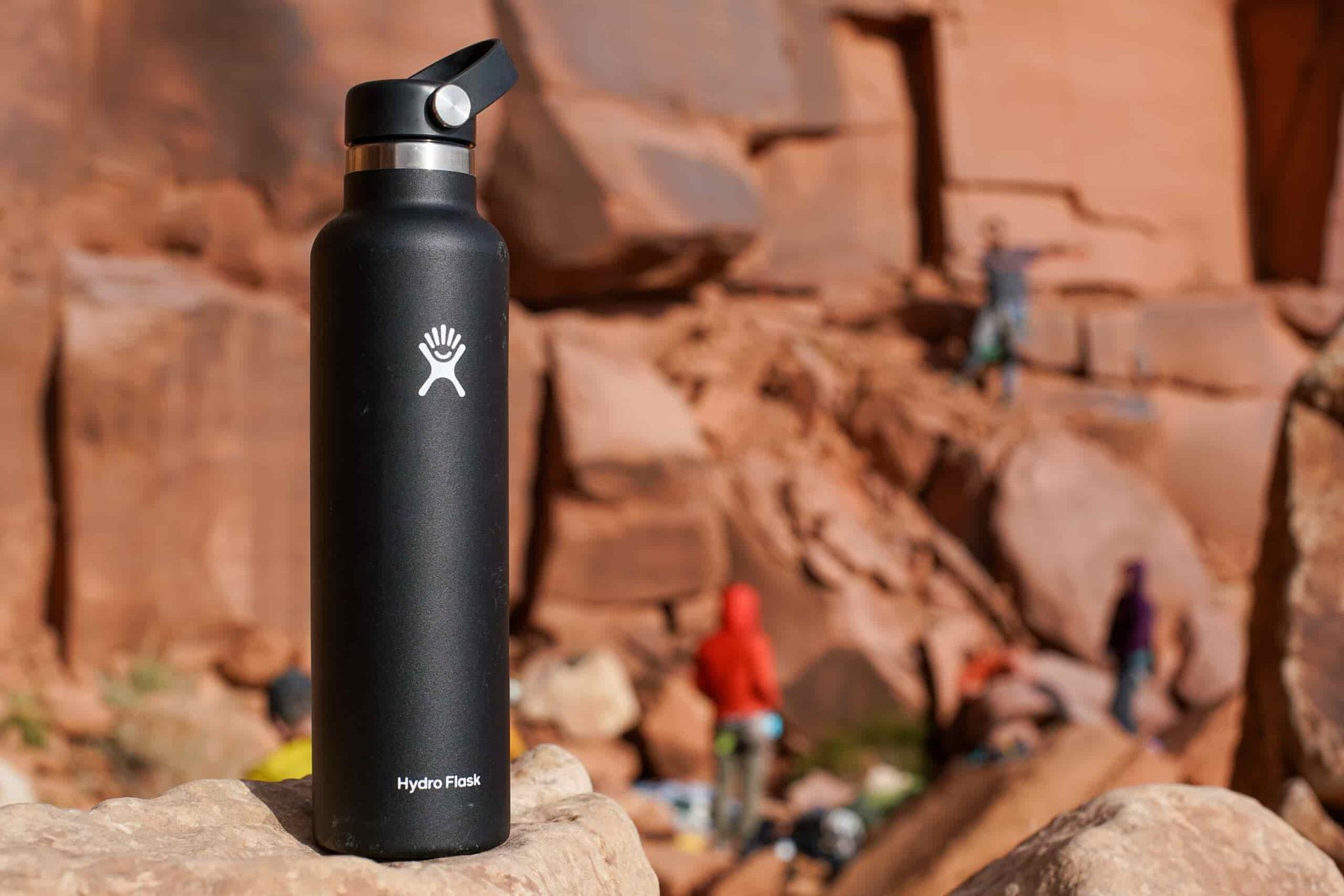 The Hydro Flask Standard Mouth sits on a rock with several climbers in the background.